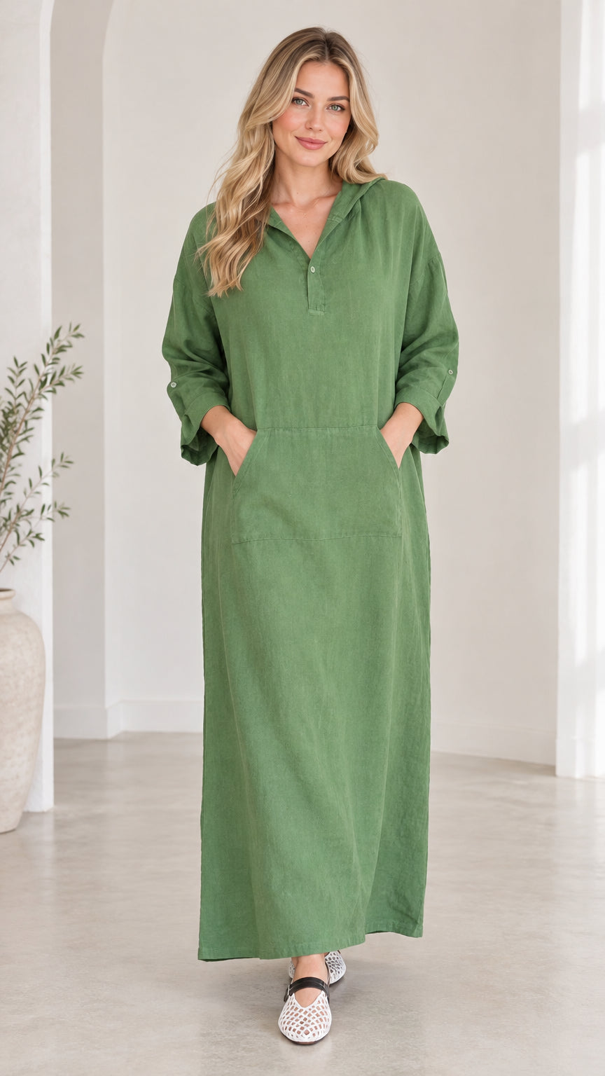 Front view of woman wearing green hooded maxi dress with pockets