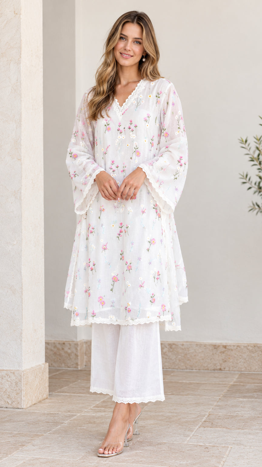 Front full-length view of woman wearing white floral embroidered tunic and wide-leg pants set