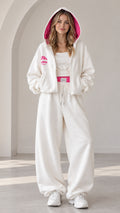 Front view of model wearing off-white two-piece tracksuit with hot pink lined hood