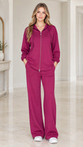 Front full view of woman wearing berry purple zip-up hoodie and wide-leg pants set