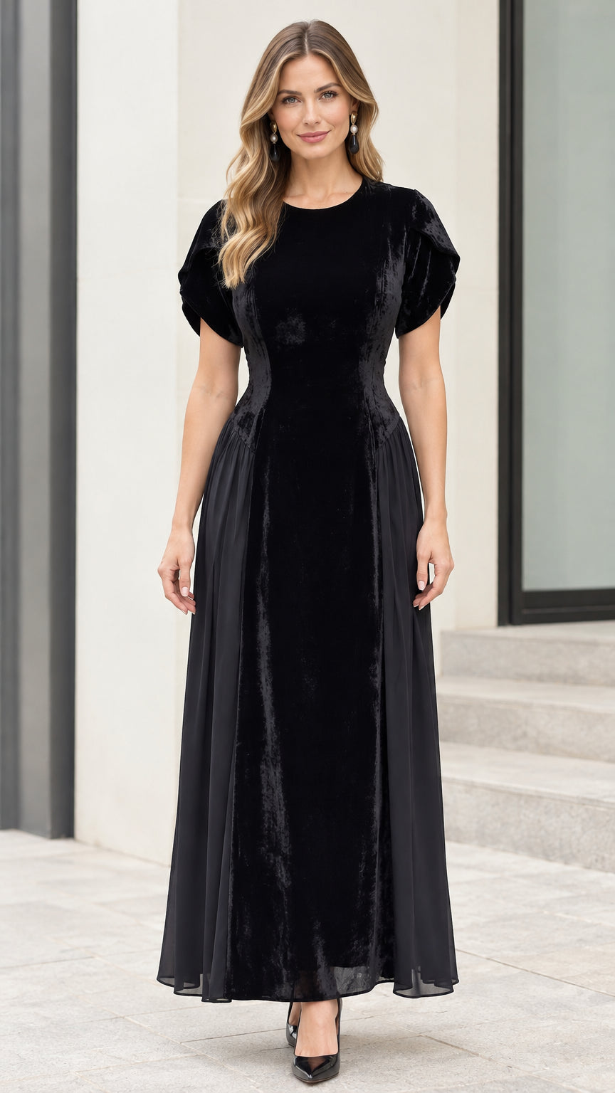 Front full-length view of model wearing black velvet tulip sleeve maxi dress