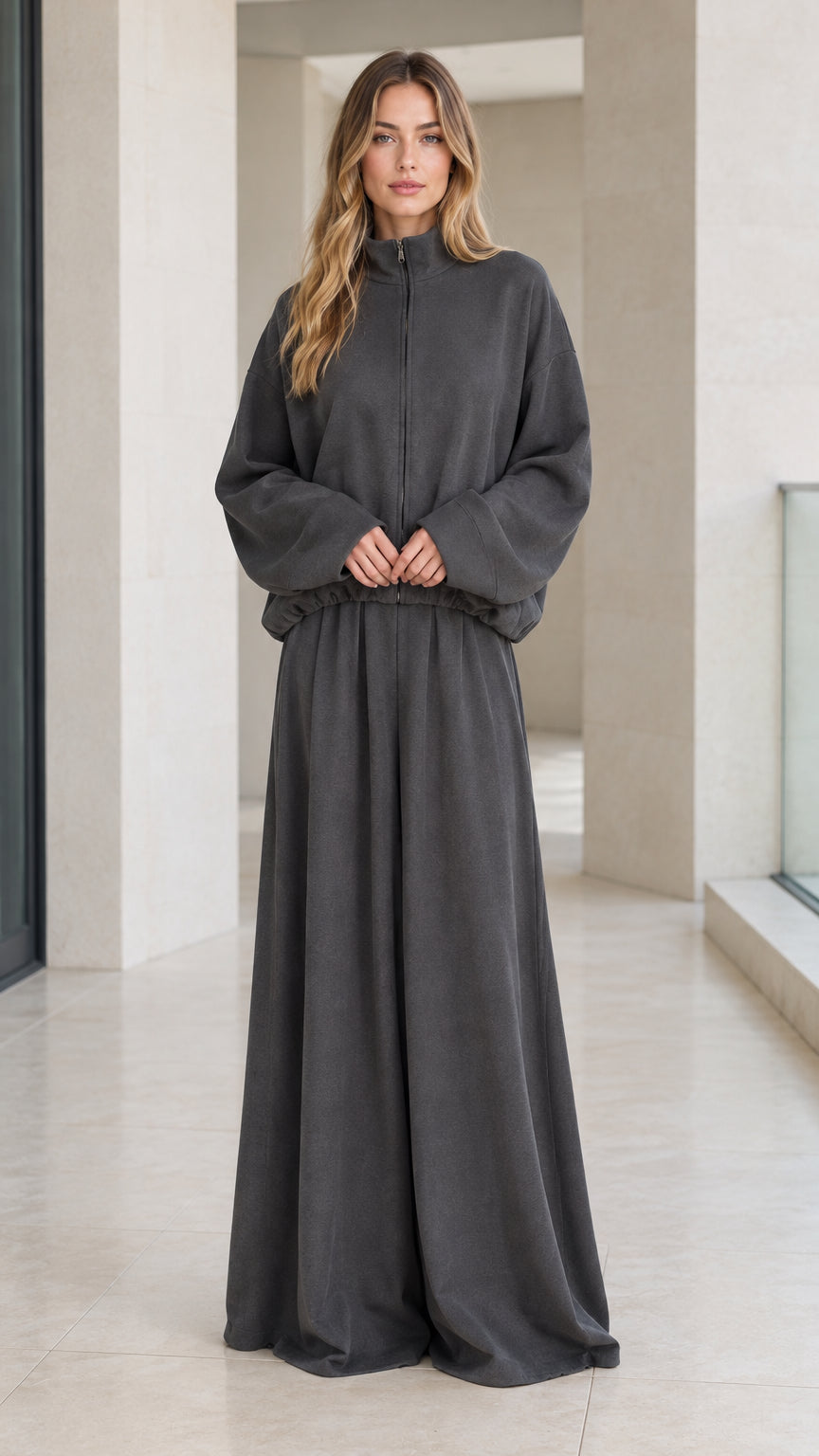 Front full view of woman wearing charcoal grey zip-up mock neck jacket and wide-leg lounge pants set