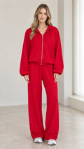 Front view of woman wearing red 2-piece zip-up hoodie and wide-leg pants tracksuit set