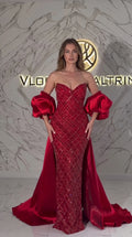 Front view of model wearing Ruby Red strapless sequin mermaid evening gown with satin train and puff sleeves