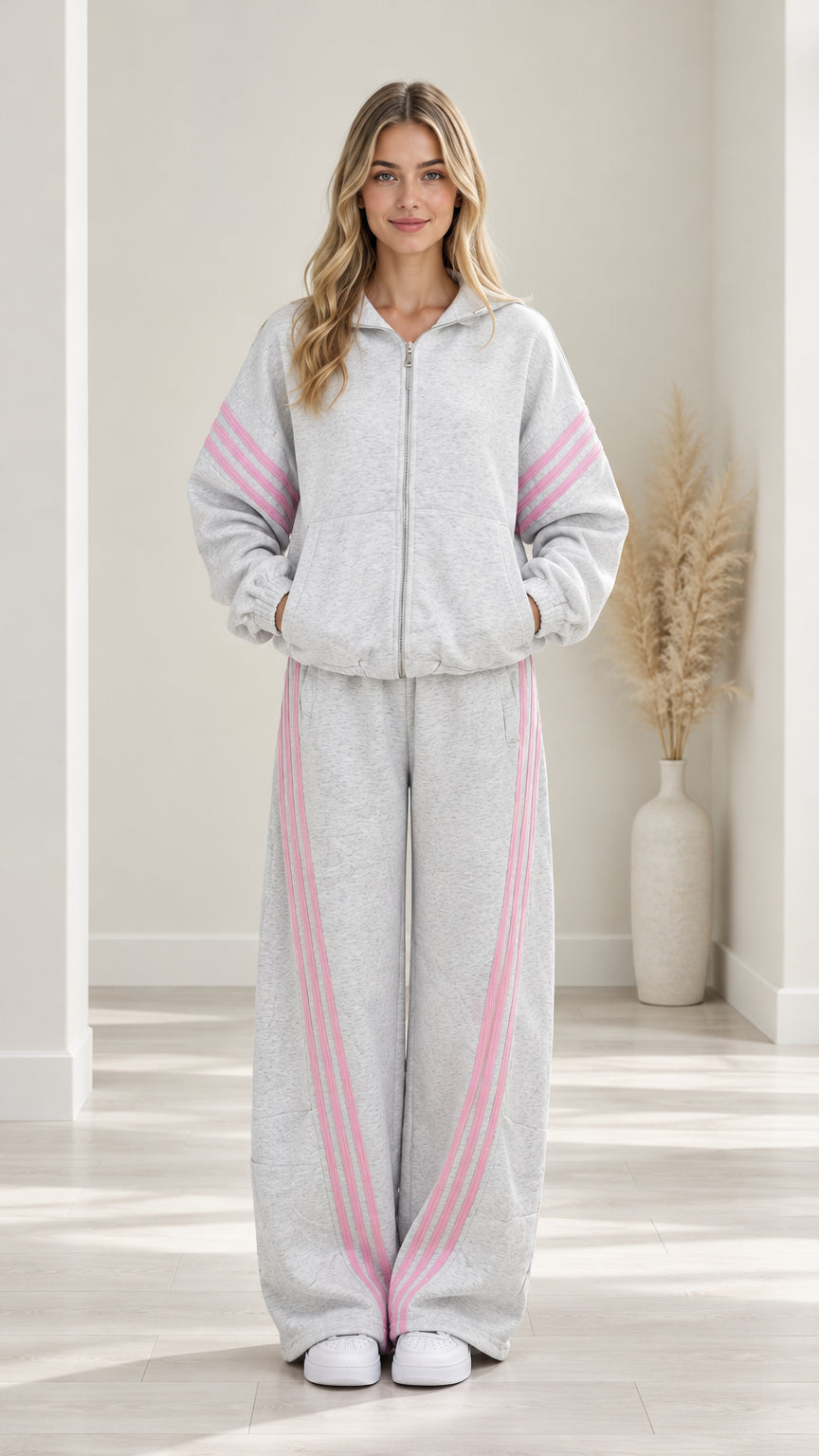 Front view of woman wearing Heather Grey two-piece tracksuit set with pink stripes