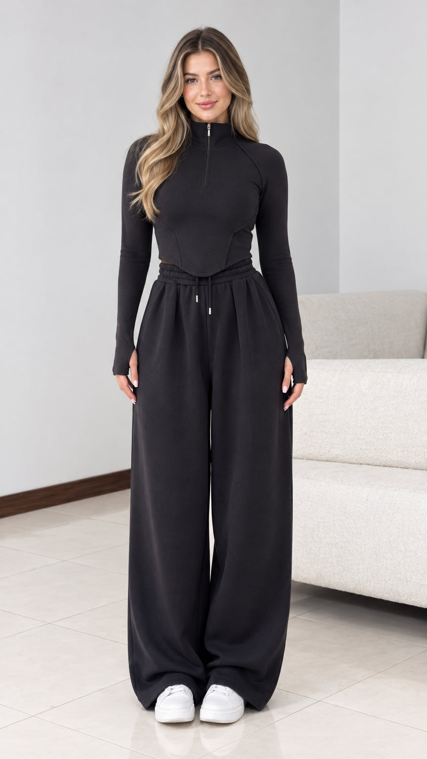Front view of model wearing black half zip top and wide leg sweatpants lounge set