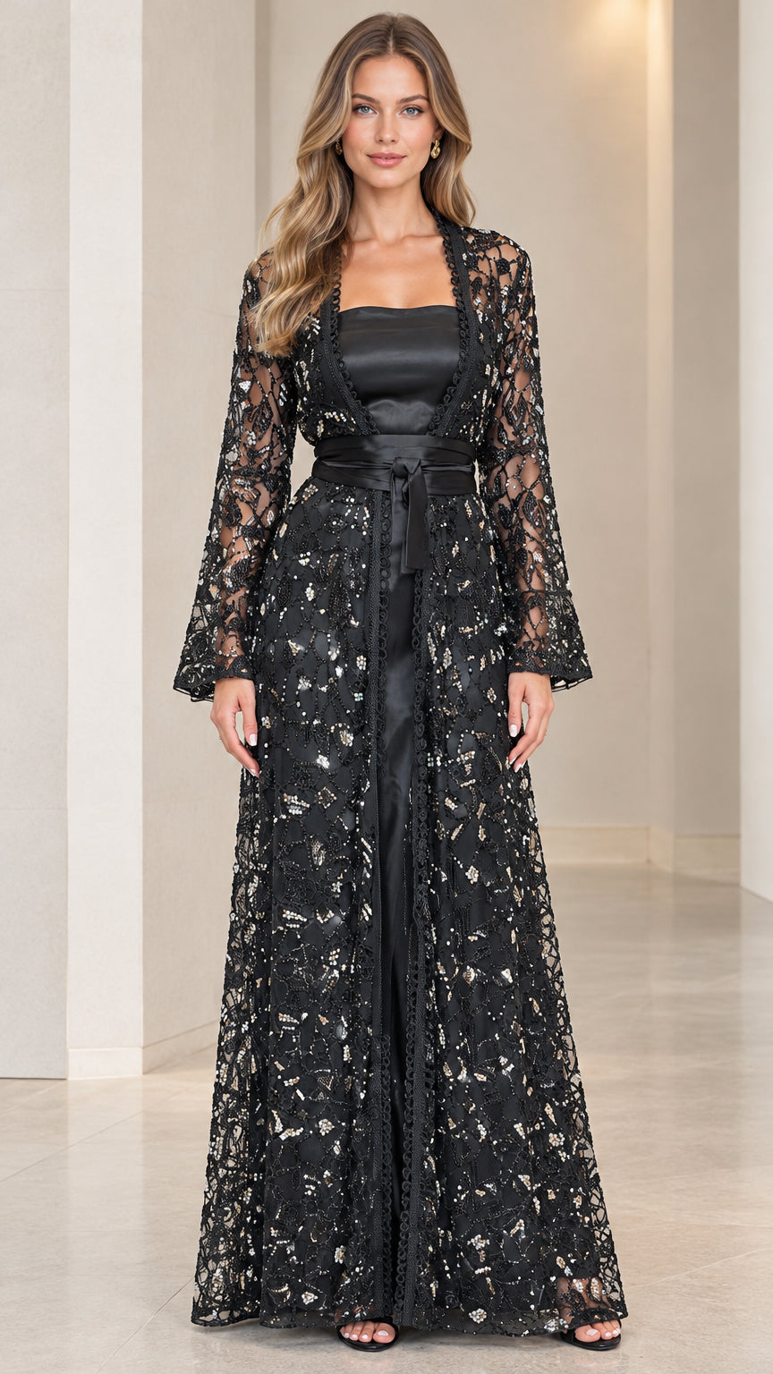 Model wearing black sequin embroidered lace duster jacket over black satin maxi gown with tie belt