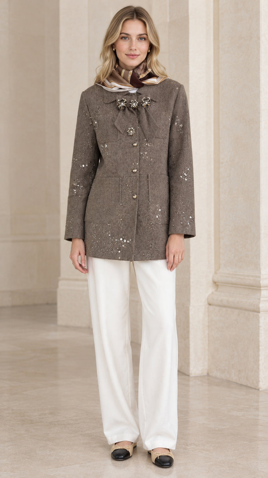 Full front view of model wearing taupe sequin embellished tweed jacket with white trousers