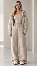Front view of model wearing the oatmeal 3-piece cropped hoodie and wide-leg sweatpants set