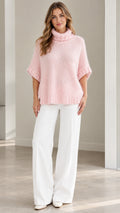Front view of model wearing Light Pink short sleeve fuzzy turtleneck poncho sweater with white wide-leg trousers