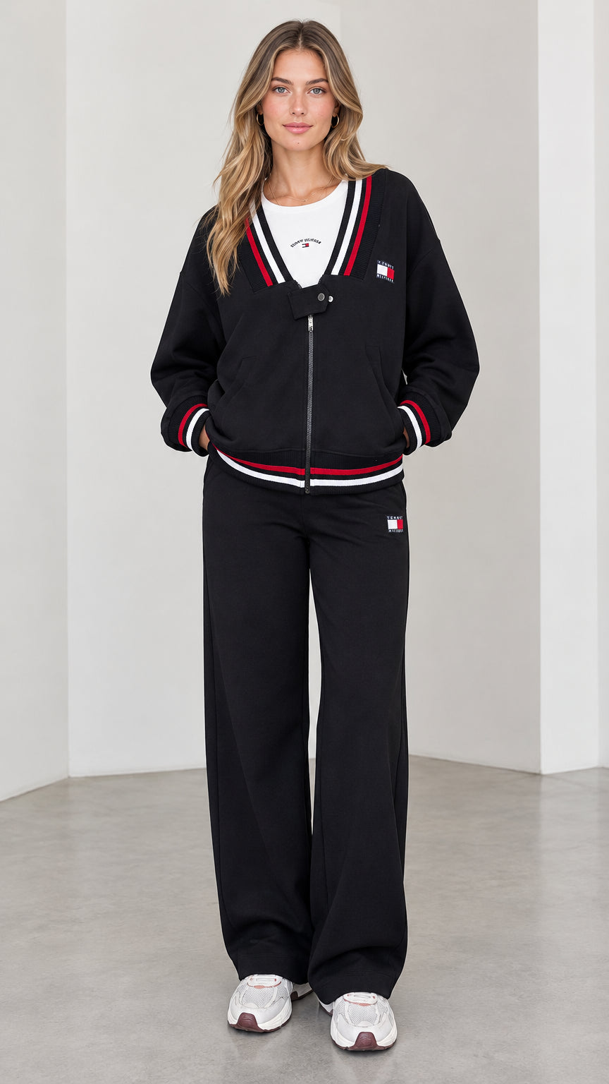 Full front view of model wearing black varsity striped zip jacket and wide leg sweatpants set