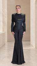 Front full view of black pleated cape long sleeve maxi evening gown with gold bar accent