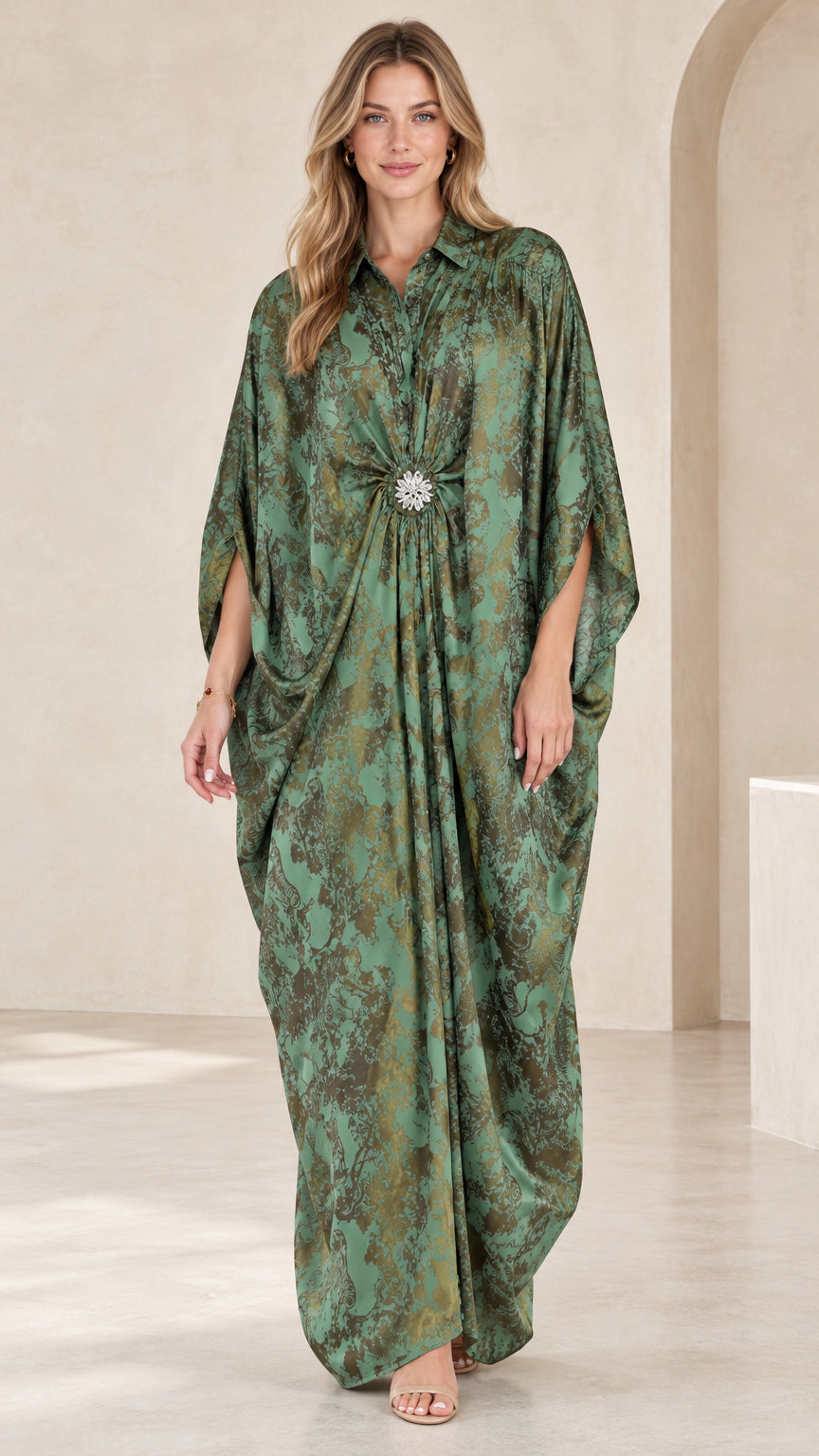 Front full view of woman wearing emerald green printed kaftan maxi dress with crystal brooch