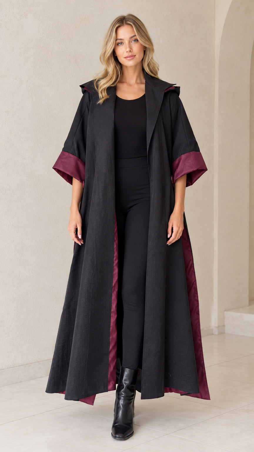 Front view of black hooded maxi duster coat with wine contrast cuffs