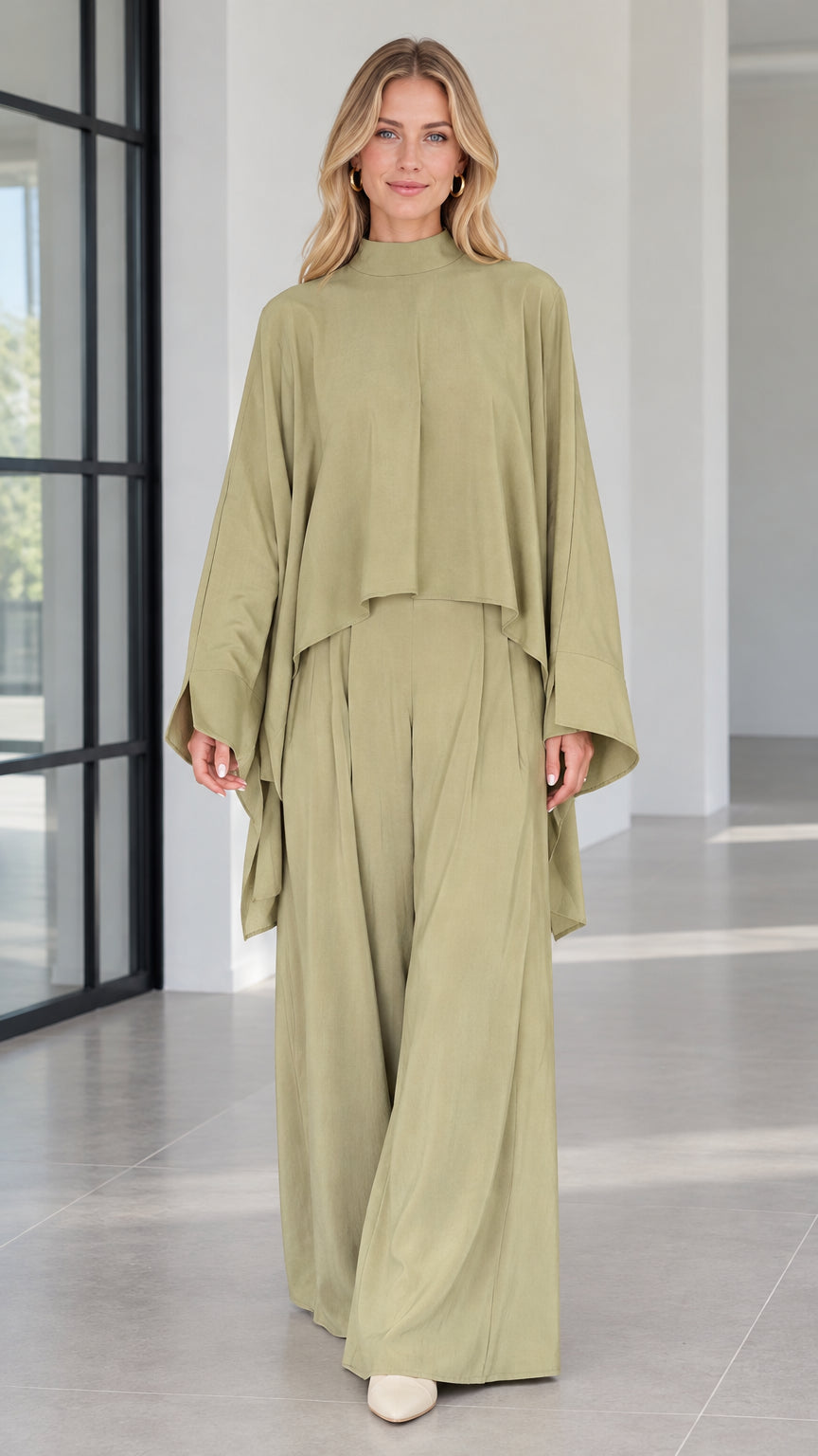 Front view of woman wearing sage green mock neck cape top and matching wide leg pants set