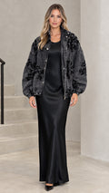 Washed black floral sequin embellished denim jacket styled over a black satin slip dress