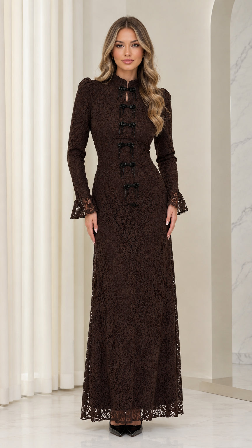 Front full view of woman wearing chocolate brown floral lace long-sleeve maxi dress with bow detailing