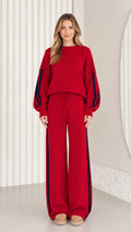 Front view of model wearing red knit two-piece lounge set with navy side stripes