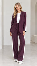 Full front view of model wearing burgundy 2-piece blazer and wide-leg pants suit with white side stripes