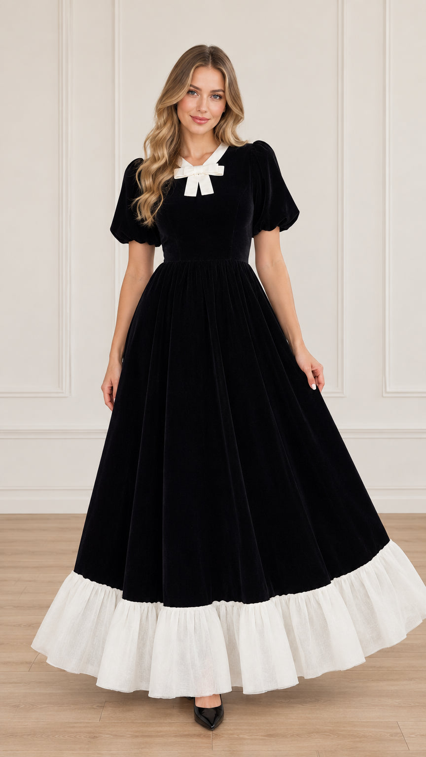 Front view of black velvet maxi dress with white bow collar and white ruffle hem