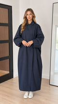 Front full-length view of woman wearing navy blue oversized maxi trench coat