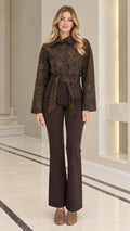 Full front view of model wearing coffee brown textured jacquard belted jacket with brown flare pants