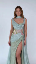 Front view of model wearing Sage Green draped cowl neck cape evening gown with slit