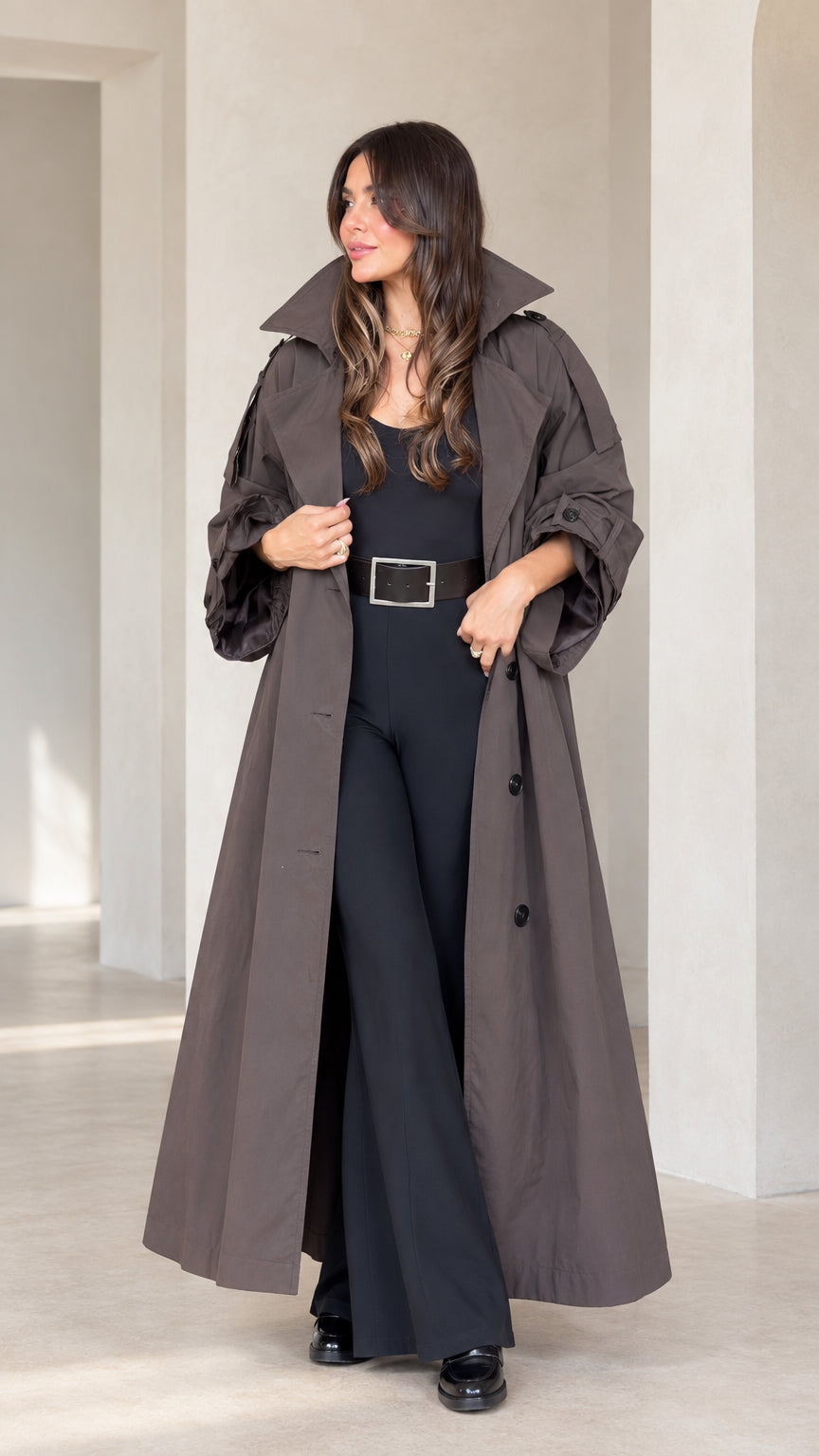 Front full view of woman wearing charcoal brown maxi trench coat with volume sleeves