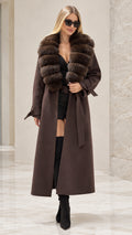 Front full view of woman wearing brown maxi trench coat with faux fur collar and belt