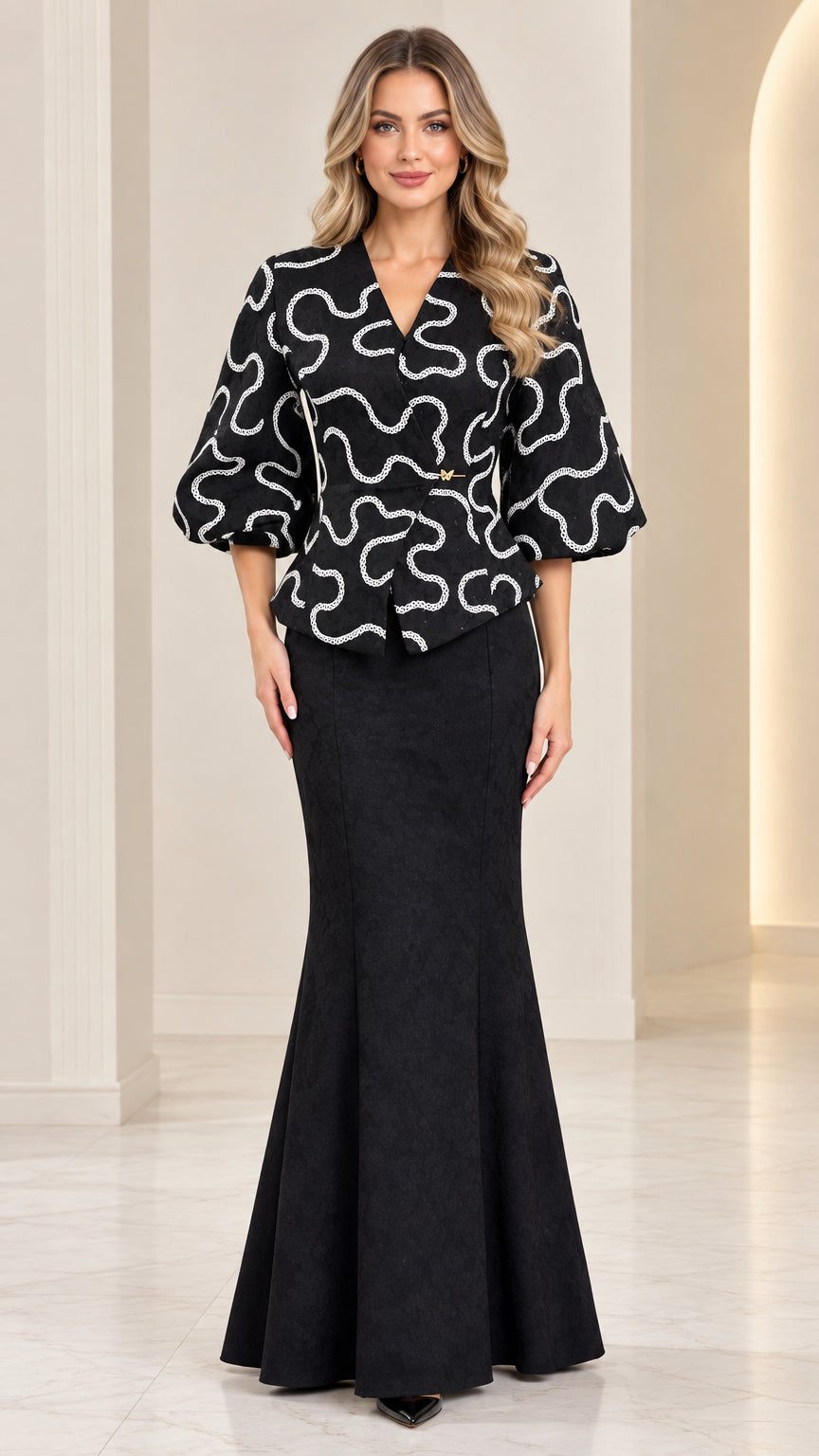 Full front view of model wearing black textured peplum top and mermaid maxi skirt set
