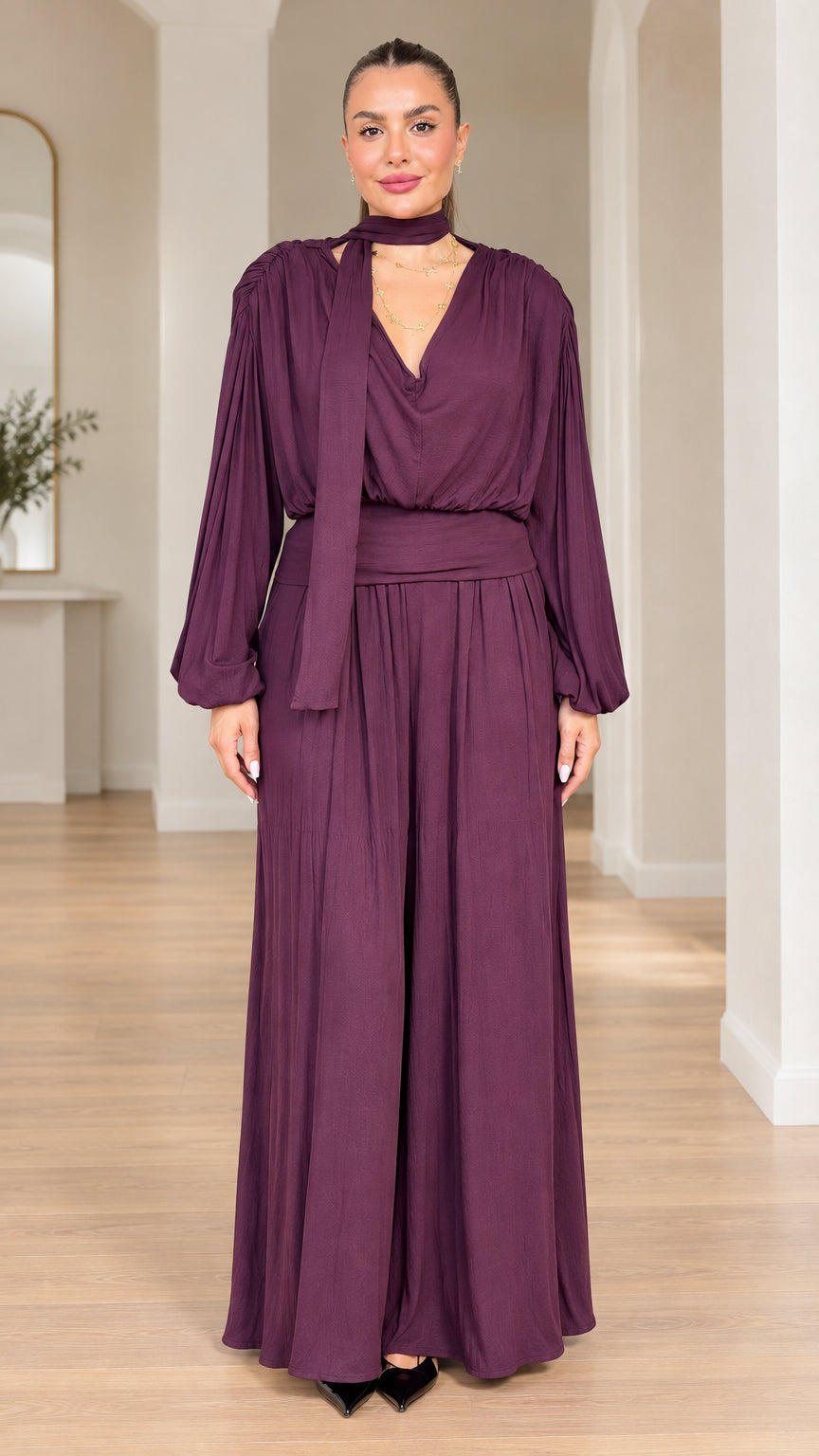 Model wearing plum long-sleeve scarf neck wide-leg jumpsuit front view
