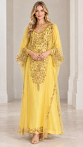 Front view of woman wearing yellow floor-length kaftan dress with intricate gold embroidery