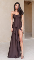 Front full-length view of model in chocolate brown strapless draped maxi dress with front slit