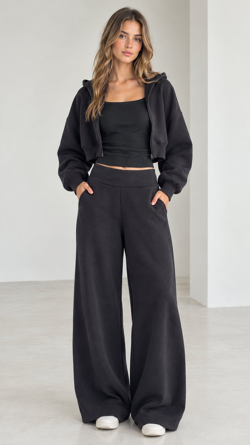 Full front view of model wearing the black 3-piece cropped hoodie, tank, and wide-leg sweatpants set