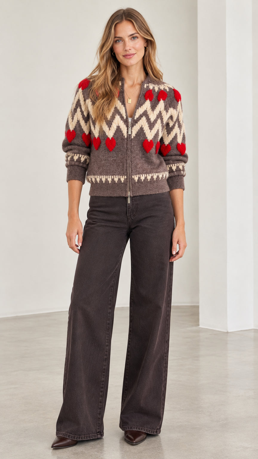 Front full view of woman wearing mocha brown chevron heart zip-up knit cardigan with wide-leg jeans