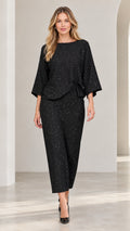 Front view of model wearing black shimmer speckled two-piece top and pant set with black heels