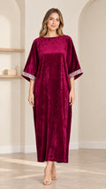 Full front view of model wearing burgundy crushed velvet kaftan maxi dress with embroidered cuffs