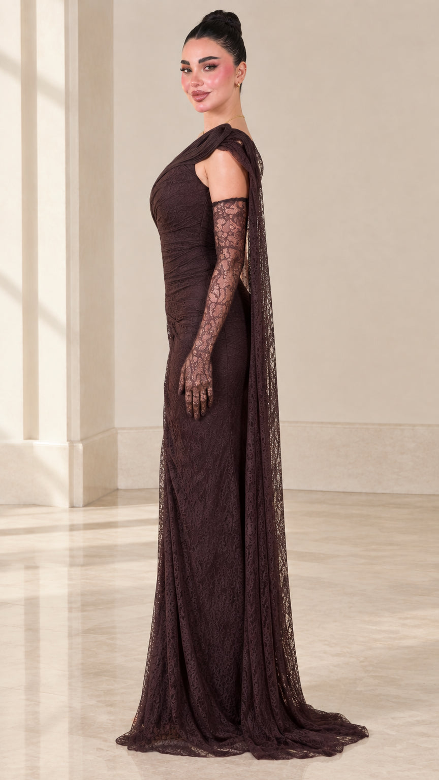 Side profile of dark brown lace formal gown showing sleek draped fit and floor length cape