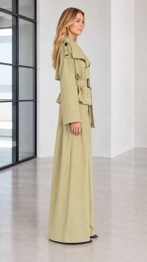 Side profile of woman in sage green two-piece trench jacket and wide trousers