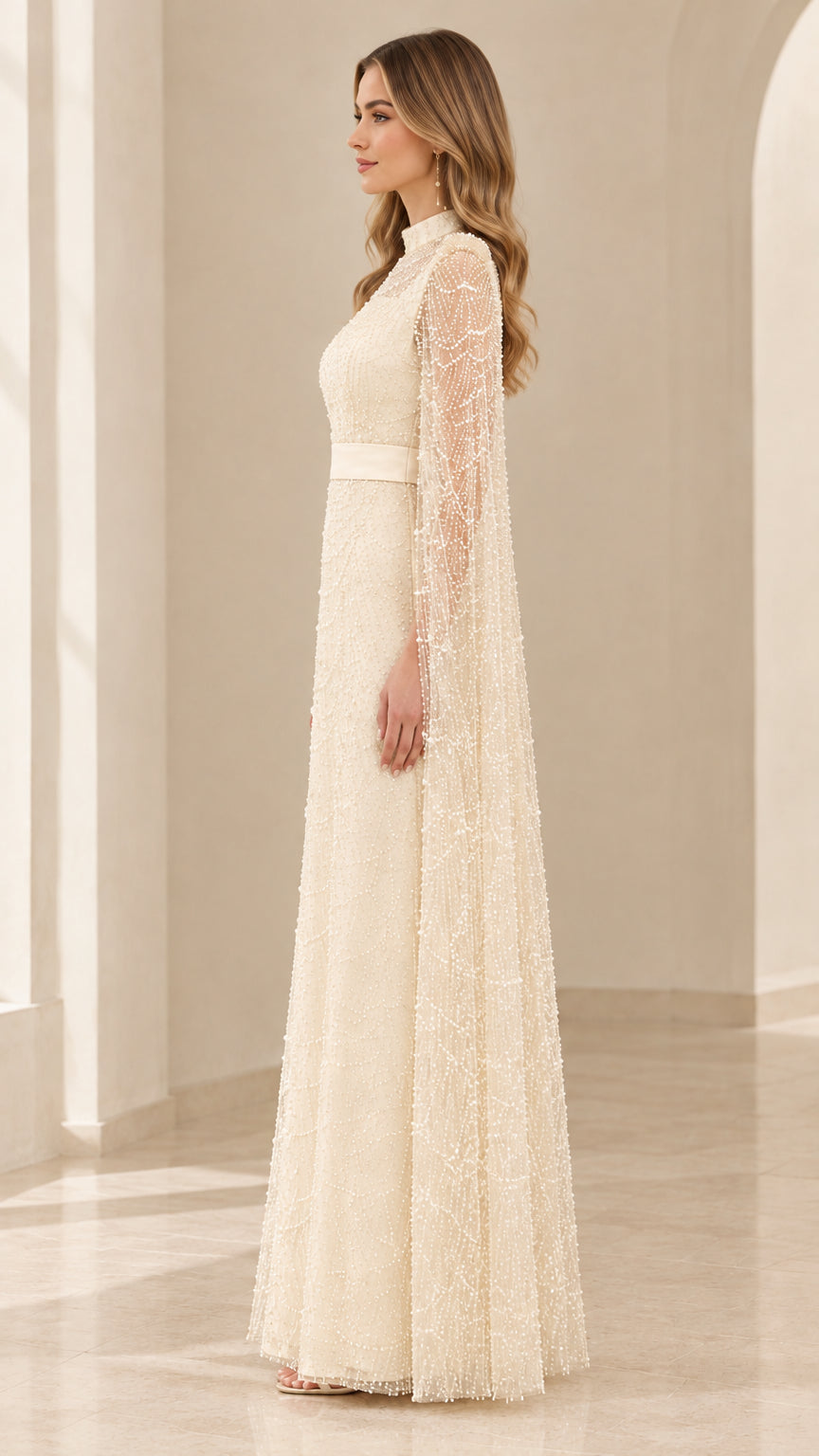 Side profile of champagne beaded formal dress with floor-sweeping cape sleeves