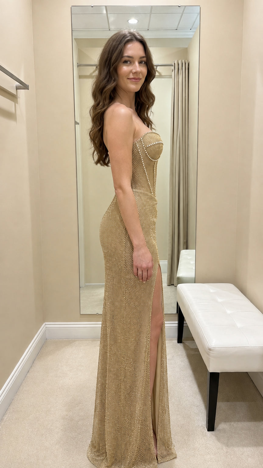 Side profile view of gold shimmer evening gown with thigh-high slit