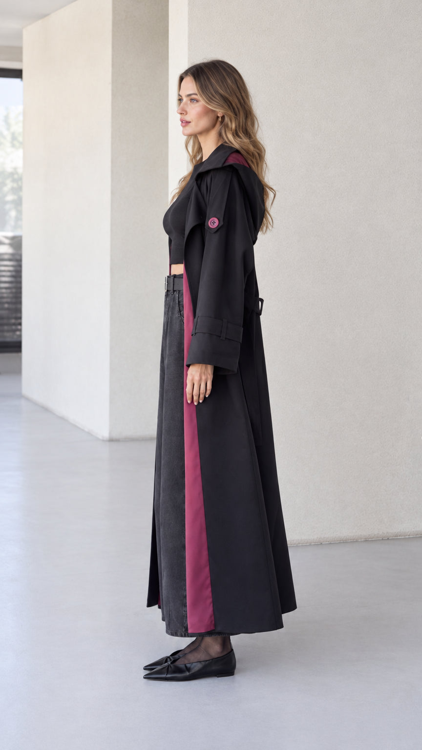 Side profile view of women's black floor-length hooded duster coat showing relaxed drape