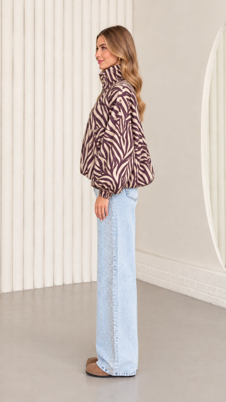 Side profile view of mocha brown zebra print blouson jacket showing sleeve volume and high stand collar