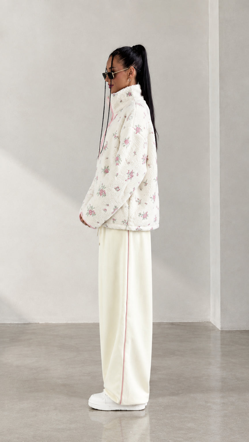 Side profile view of model wearing cream floral half-zip fleece jacket