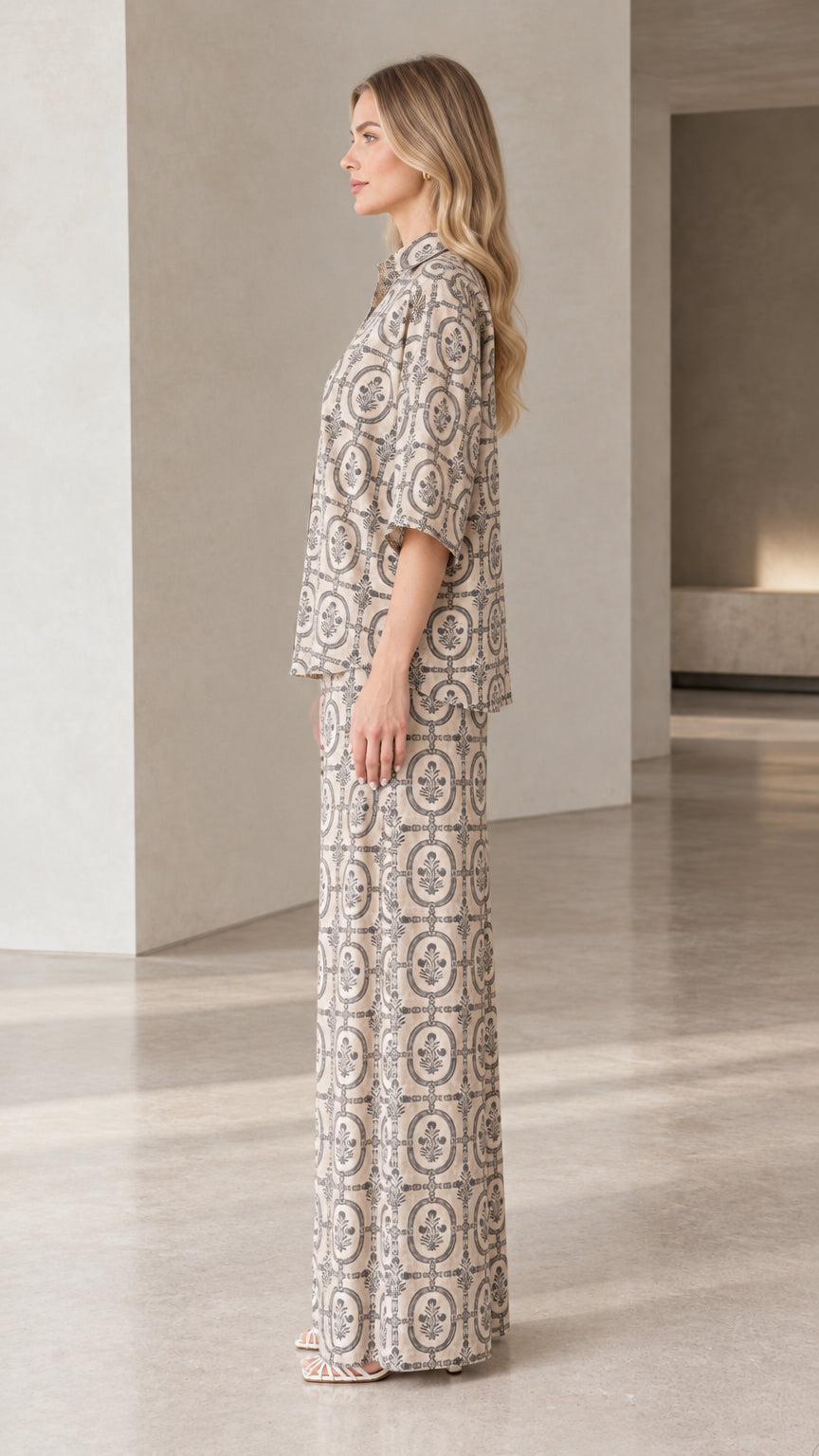 Side profile view of woman modeling beige printed two-piece shirt and pants set