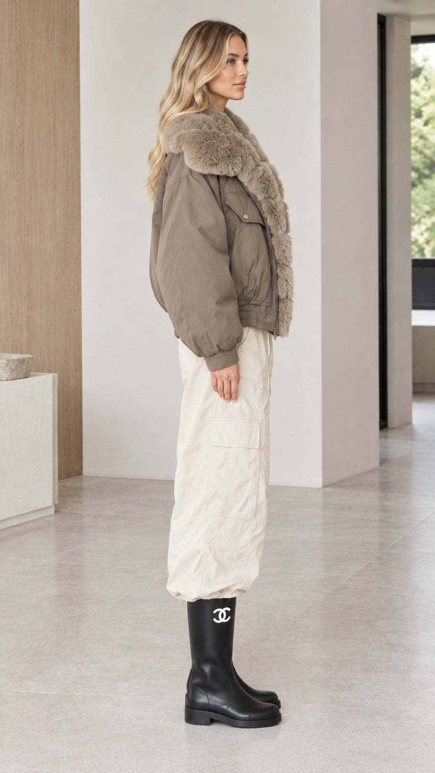 Side view of model styled in taupe bomber jacket with plush fur trim