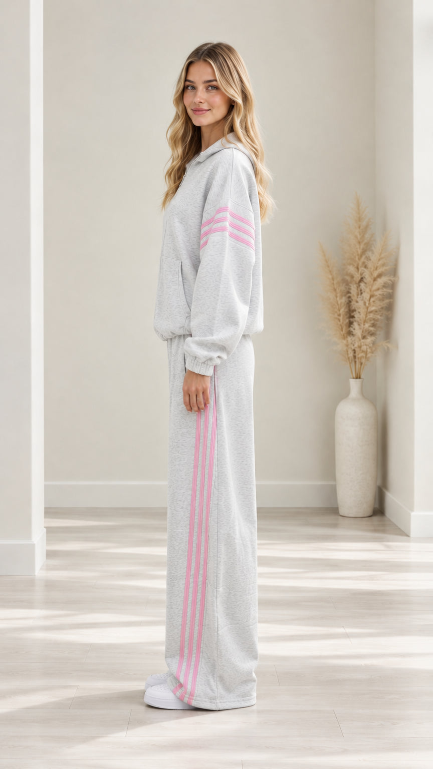 Side profile view of woman wearing Heather Grey zip tracksuit and wide-leg pants