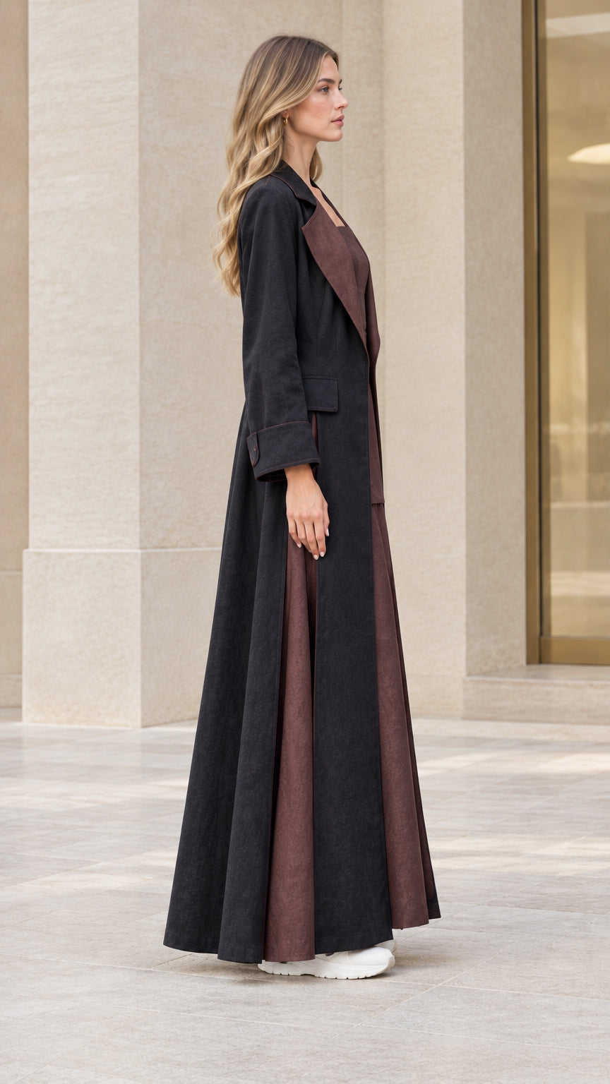 Side profile view of woman wearing dramatic floor-length black duster coat