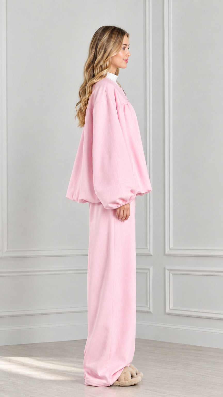 Side profile of model in light pink balloon sleeve jacket and wide-leg pants