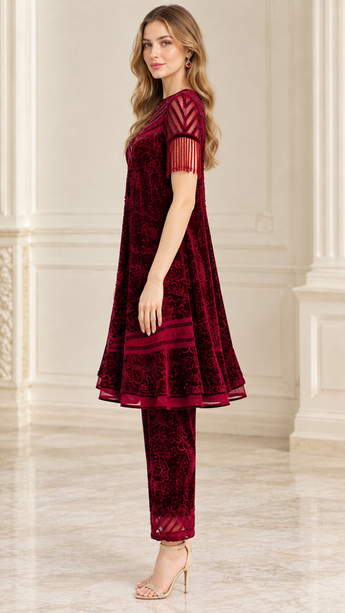 Side profile view of burgundy flared velvet tunic and straight trousers